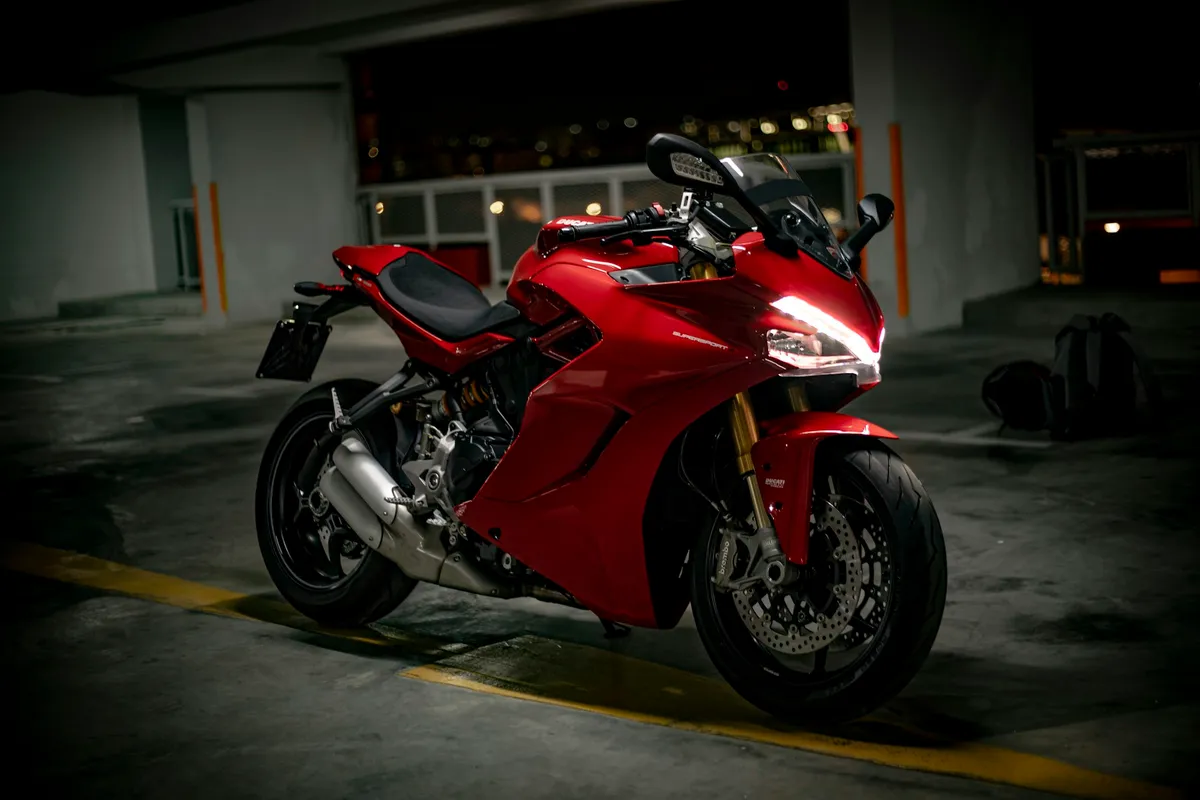 Moto deportiva roja en un garaje con poca luz