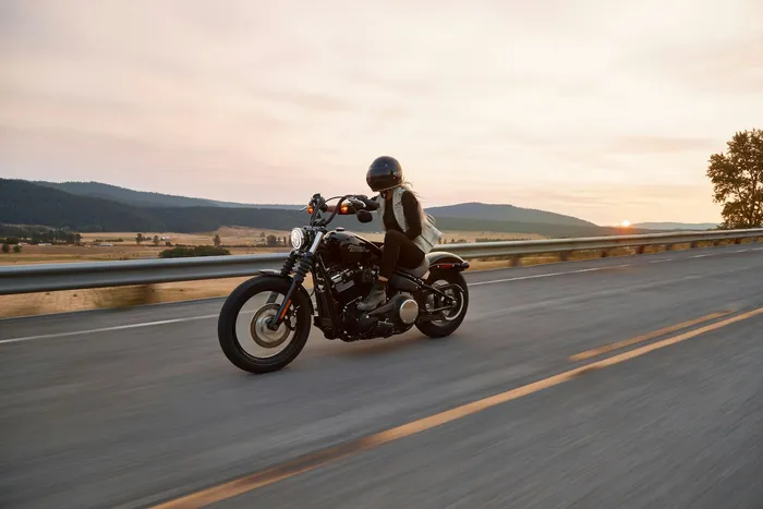 Motorista con casco integral en una carretera al atardecer